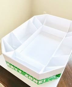 an empty white box sitting on top of a wooden table