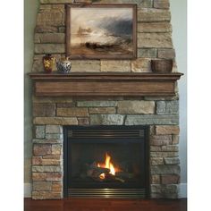 a fire place with a painting on the wall above it and a fireplace in front of it