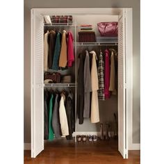 an open closet with clothes and shoes hanging on the doors, in front of a hardwood floor