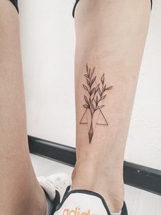 a woman's foot with a small tattoo on her left leg and a flower in the middle