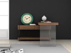 a clock sitting on top of a wooden table next to a magazine rack and vase