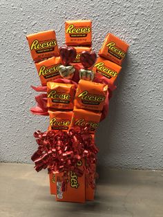 a bouquet of reese's candy wrapped in red ribbon and tied to a wall