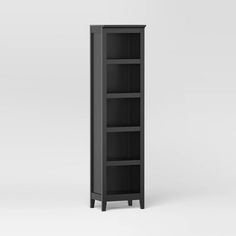 a tall black bookcase sitting on top of a white floor