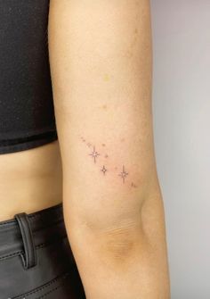 a woman's arm with small stars on the back of her left arm,