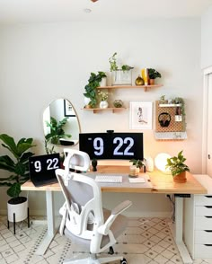 a desk with a chair, mirror and plants on it