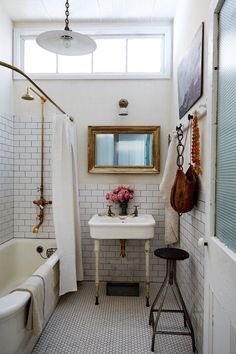 a bathroom with a sink, mirror and bathtub in it's center area