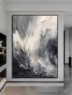 a large black and white painting hanging on the wall