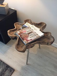 a wooden table with a magazine on it next to a lamp and other items in a room