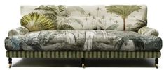 an upholstered couch with palm trees on the back and green, striped fabric