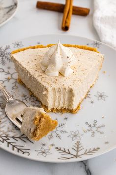 a piece of pie on a plate with a fork and cinnamon sticks in the background