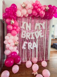 balloons and streamers are on the floor in front of a pink backdrop that says, i'm my brother era