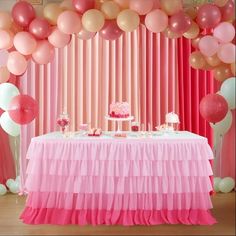 a pink and white dessert table with balloons