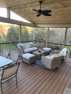 a covered deck with wicker furniture and ceiling fan