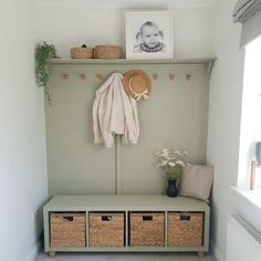 a coat rack with three baskets and a hat hanging on the wall next to it