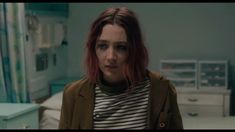 a woman with red hair standing in a hospital room