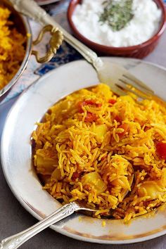 a white plate topped with yellow rice and vegetables