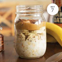 a jar filled with food sitting on top of a wooden table next to a banana