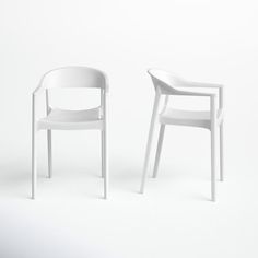 two white chairs sitting next to each other in front of a white wall and floor