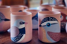 there are many cups that have birds painted on the inside of them, and one has a blue eye