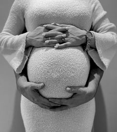 a pregnant woman holding her hands on her belly