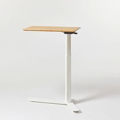 a white table with a wooden top on a white base and a black handlebar