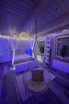 a bedroom with purple lights and a hanging chair