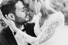 a bride and groom kissing each other in black and white