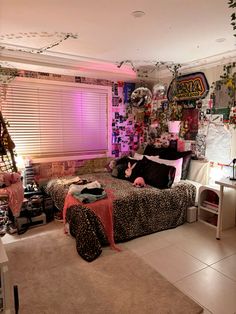 a bedroom decorated in leopard print with pink lights and decorations on the wall above the bed