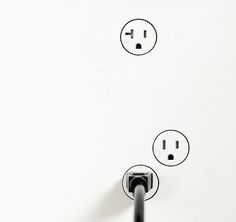 an electrical outlet with three plugs and two wires connected to each other on a white wall