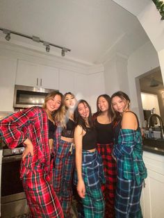 four girls in matching pajamas posing for the camera