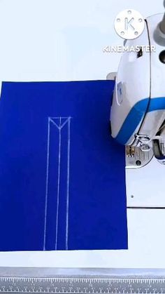 a blue piece of paper next to a sewing machine