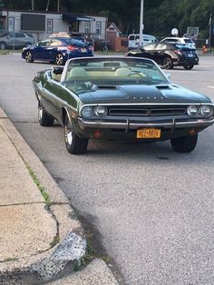 an old muscle car parked on the side of the road