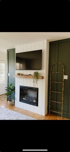 a living room with a large flat screen tv mounted on the wall next to a fireplace