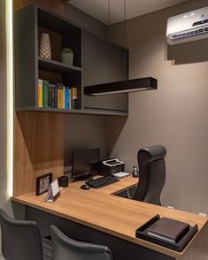 an office cubicle with a desk, chair and bookshelf in the corner