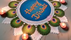 a birthday cake with peacock feathers and candles around it that says happy diwali