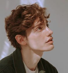 a close up of a person wearing a jacket and looking off into the distance with his eyes closed