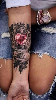 two women holding hands with tattoos on their arms and one has a heart in the middle