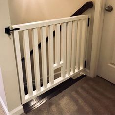 an open door with a white railing in front of it and a light on the wall