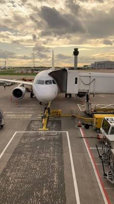 an airplane is parked on the tarmac with other vehicles around it and in front