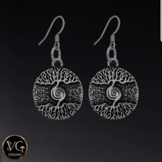 the earrings are made from silver and features an intricate tree design on each earring