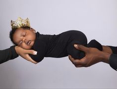 a baby is sleeping on its mother's lap with a crown on her head