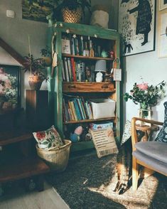 a living room filled with furniture and bookshelves next to a wall covered in pictures