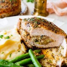 a plate with meat, mashed potatoes and asparagus on it next to other food items