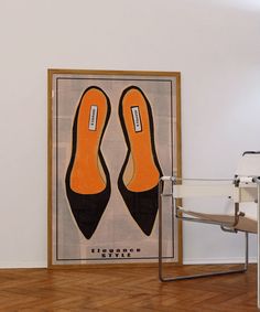 an orange pair of shoes sitting on top of a wooden floor next to a white chair