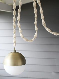 a white light hanging from a ceiling in front of a house