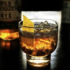 a glass filled with ice and an orange peel