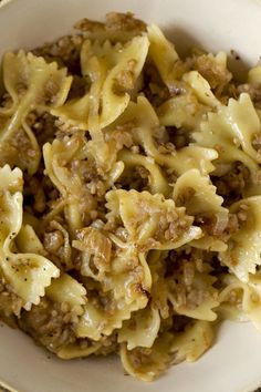 a white bowl filled with pasta and meat