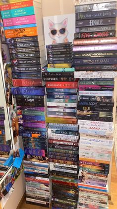 there are many books stacked on top of each other in the store, all piled up together