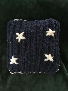 a crocheted pillow with white stars on it