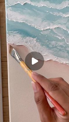 someone is painting waves on the beach with watercolors and acrylic paint